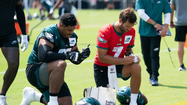 Jordan Mailata and Joe Flacco sign autographs after a recent training camp practice.